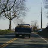 An old Ford pickup truck loaded with hay