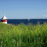 A beacon, flowers and sailing boats at the Finnish bay