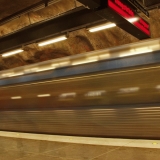 A subway train passing by a station