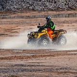 An all terrain vehicle driving through a puddle of water