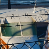 A Cessna behind a barbed wire fence