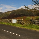 A road, a fence and mountains at Lake District