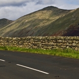 A road, a fence and mountains at Lake District