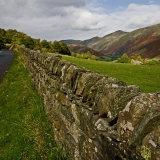 A road, a stone wall and a valley