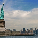 The Statue of liberty on Liberty island, the south tip of Manhattan in the background