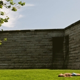 A man sunbathing at the base of the Statue of Liberty