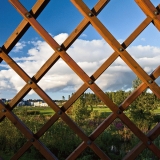 Viikinojanpuisto park seen through the grid wall of a bridge