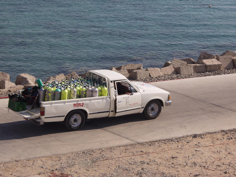 A pick-up truck loaded with compressed air bottles