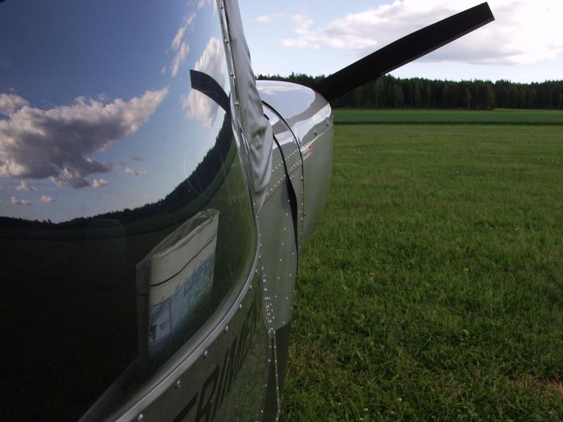 The sky reflects from the windshield of an experimental airplane