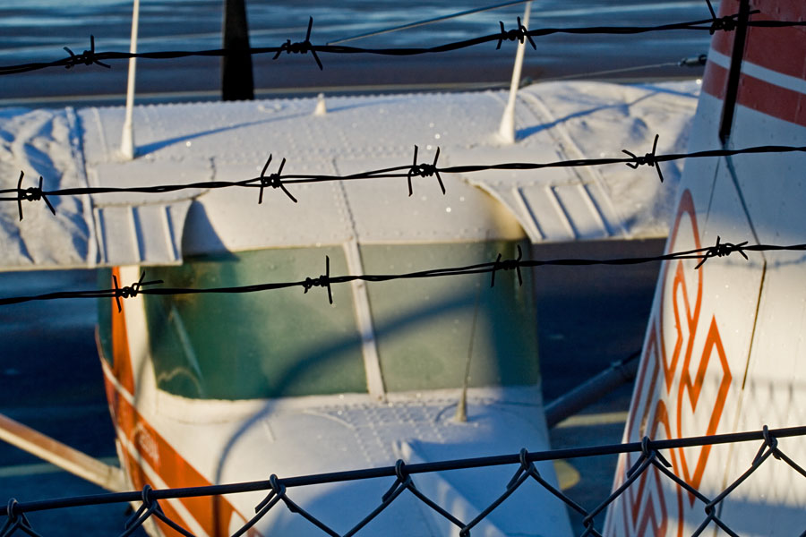 A Cessna behind a barbed wire fence