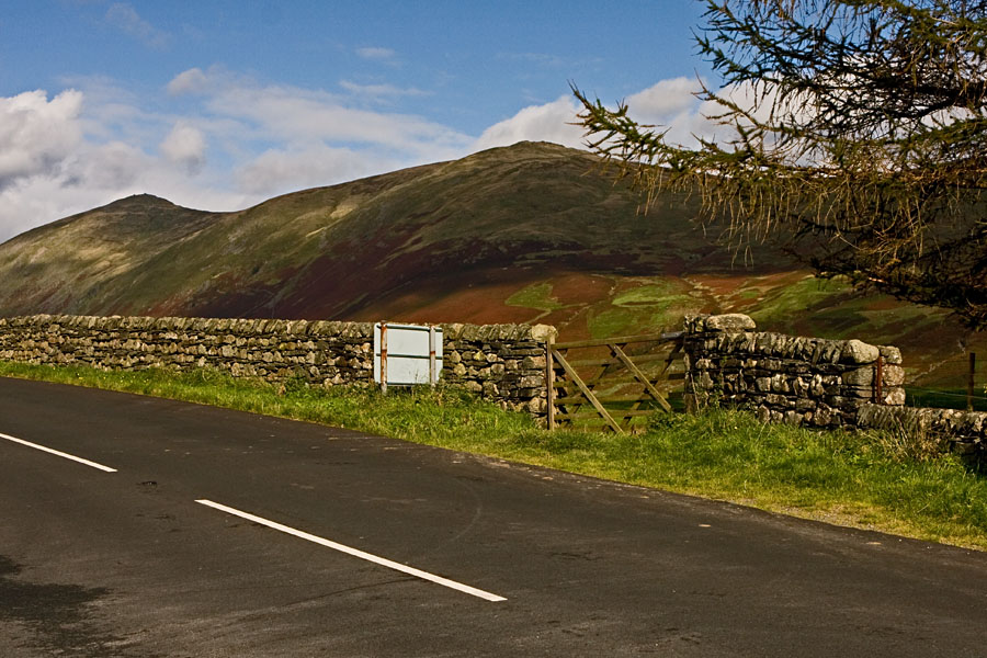 A road, a fence and mountains at Lake District