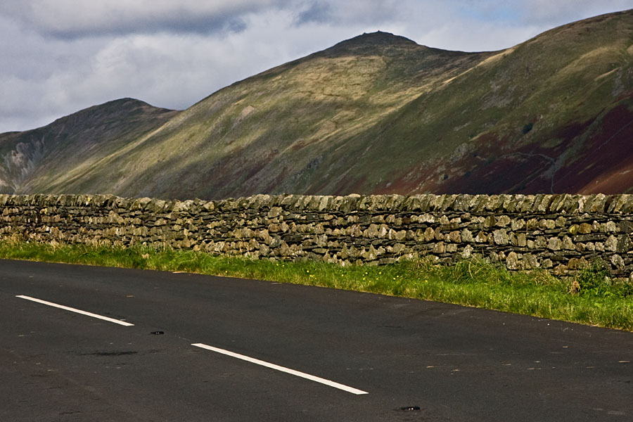 A road, a fence and mountains at Lake District