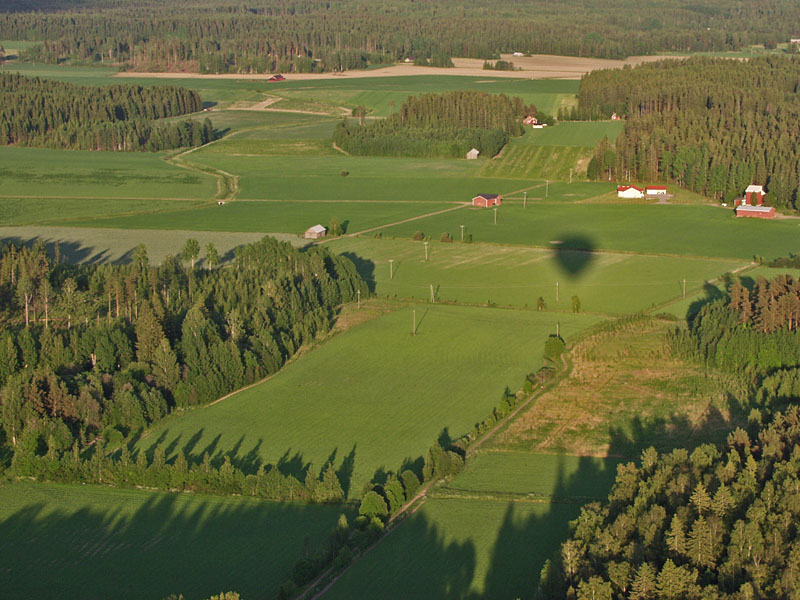 Kuumailmapallon varjo peltomaisemassa