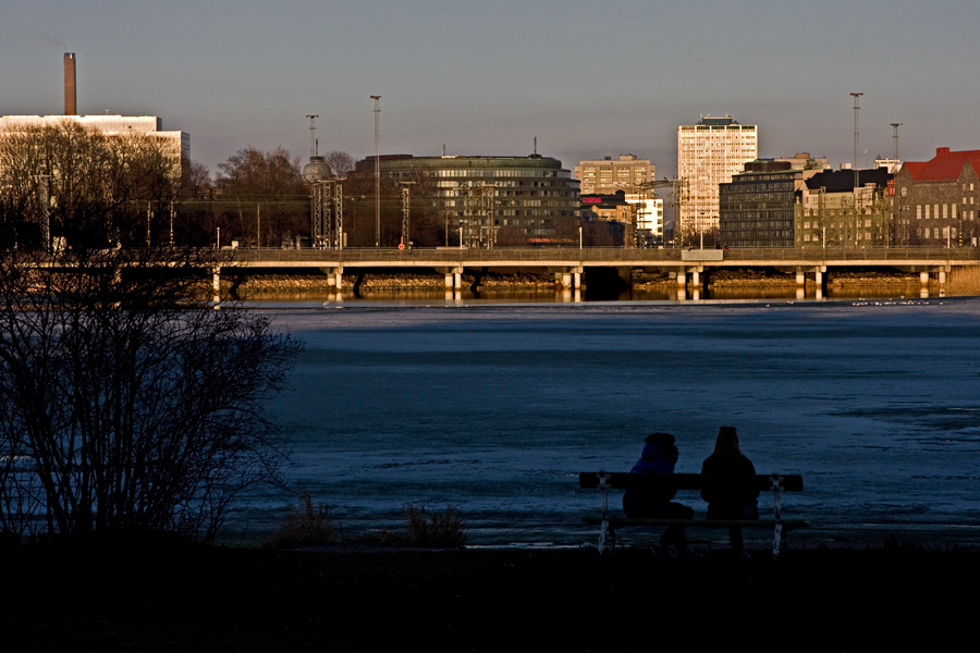 Laskeva aurinko heijastuu Hakaniemen rakennuksista Tlnlahdelle