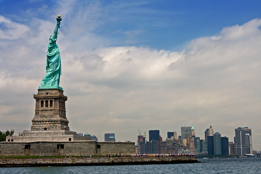 The Statue of liberty on Liberty island, the south tip of Manhattan in the background