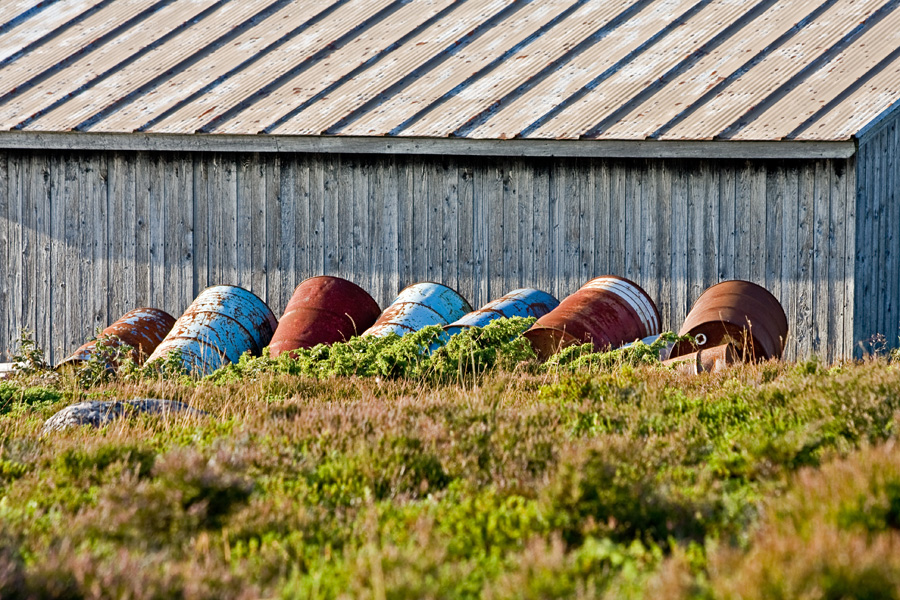 Barrels resting against a boathouse