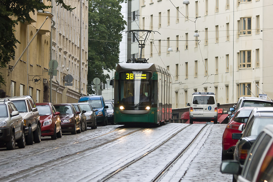 A tram and a police car pass each other at Tehtaankatu